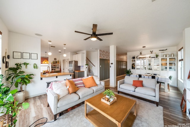 10228 Ancient Anchor, San Antonio, TX 78245 - living area with stairs, wood finished floors, a ceiling fan, and baseboards