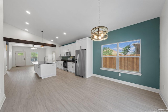 712 Gilmer, Kerrville, TX 78028 - kitchen with appliances with stainless steel finishes, open floor plan, a chandelier, white cabinets, and a center island with sink