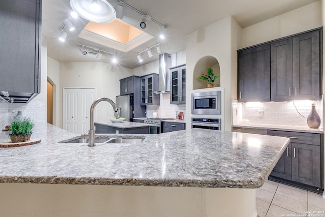 2710 Trinity Rdg, San Antonio, TX 78261 - kitchen with track lighting, wall chimney exhaust hood, appliances with stainless steel finishes, a sink, and tasteful backsplash