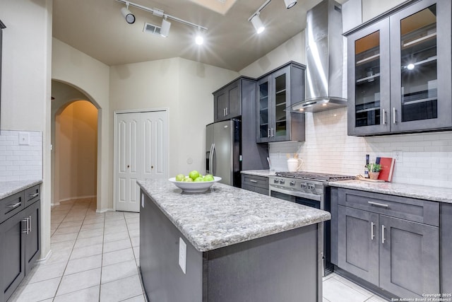 2710 Trinity Rdg, San Antonio, TX 78261 - kitchen with stainless steel refrigerator with ice dispenser, wall chimney exhaust hood, rail lighting, arched walkways, and light tile patterned floors