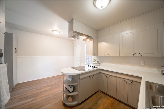 7414 Westfield Blvd, San Antonio, TX 78227 - kitchen with black electric stovetop, open shelves, a peninsula, light countertops, and wall chimney exhaust hood