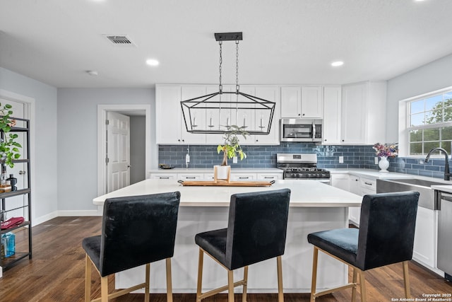 108 Bryn Mawr Dr, San Antonio, TX 78209 - kitchen with stainless steel appliances, dark wood-style flooring, tasteful backsplash, a kitchen island, and recessed lighting