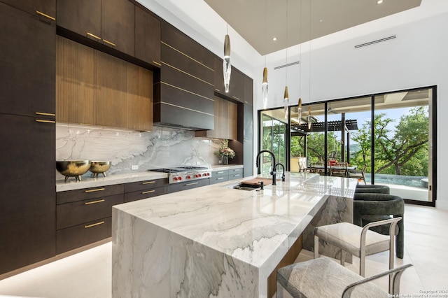 24607 Cliff Line, San Antonio, TX 78257 - kitchen with modern cabinets, a sink, tasteful backsplash, a kitchen bar, and light stone counters