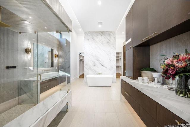 24607 Cliff Line, San Antonio, TX 78257 - bathroom with tile walls, a shower stall, a soaking tub, vanity, and a walk in closet