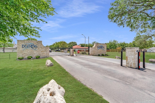 121 Maderas, Seguin, TX 78155 - view of asphalt street featuring street lights, a gate, and a gated entry