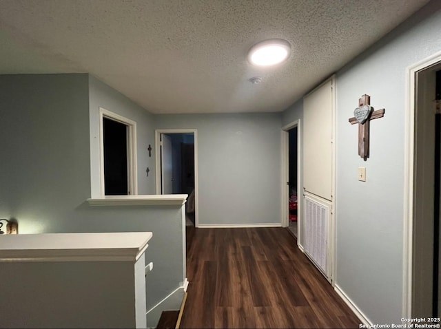 13218 Huntsman Rd, San Antonio, TX 78249 - hallway featuring a textured ceiling, dark wood-style floors, and baseboards
