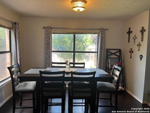 13218 Huntsman Rd, San Antonio, TX 78249 - dining space featuring a textured ceiling, wood finished floors, and baseboards