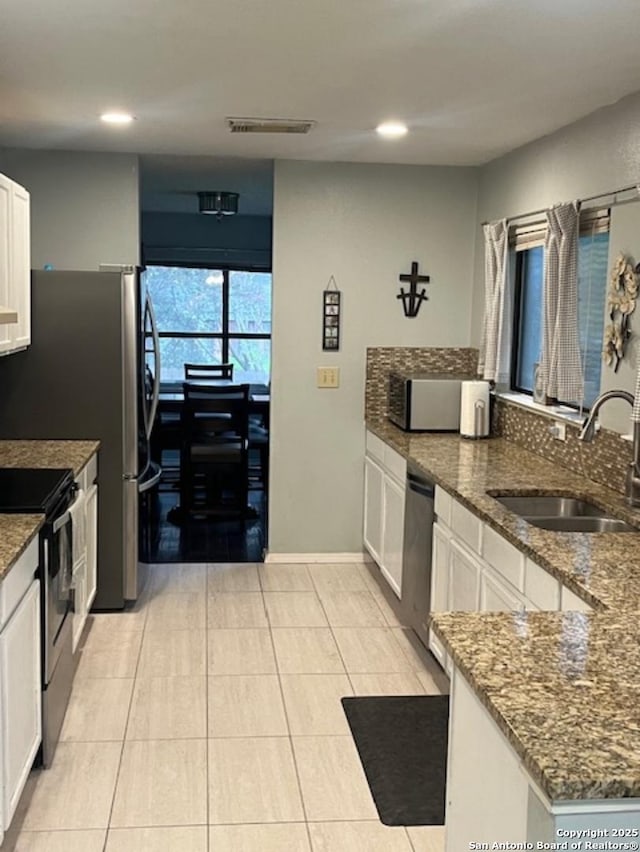 13218 Huntsman Rd, San Antonio, TX 78249 - kitchen with a sink, appliances with stainless steel finishes, recessed lighting, white cabinetry, and dark stone countertops