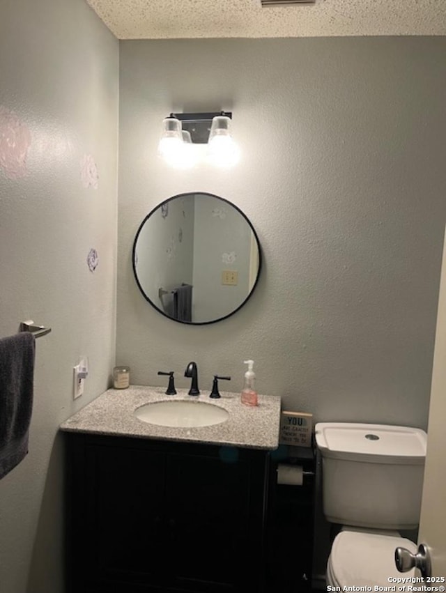 13218 Huntsman Rd, San Antonio, TX 78249 - bathroom with vanity, a textured ceiling, and toilet