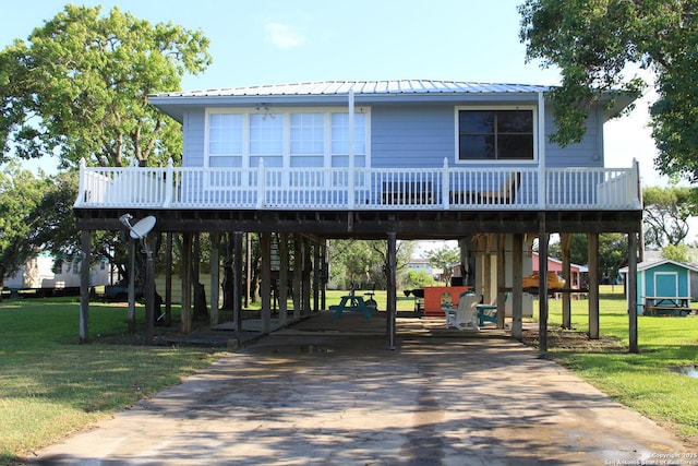 38 Peggy, Palacios, TX 77465 - raised beach house with a carport, a front lawn, a deck, and driveway