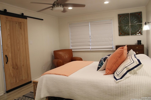 38 Peggy, Palacios, TX 77465 - bedroom with light wood finished floors, a barn door, crown molding, recessed lighting, and ceiling fan