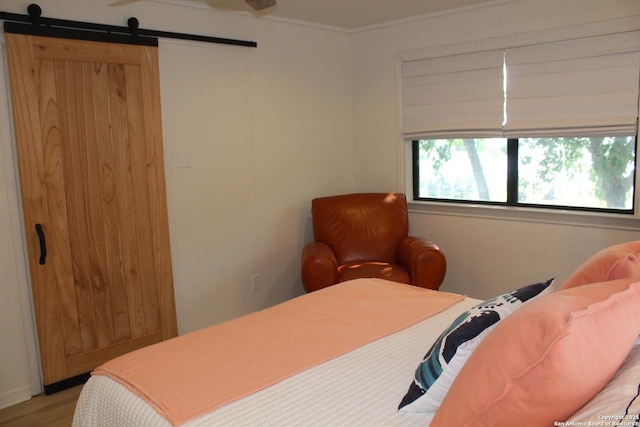 38 Peggy, Palacios, TX 77465 - bedroom with multiple windows, a barn door, light wood-type flooring, and crown molding