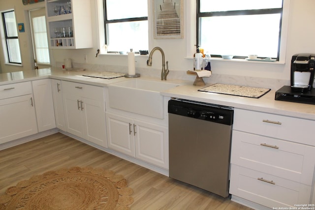 38 Peggy, Palacios, TX 77465 - kitchen with stainless steel dishwasher, a sink, light wood finished floors, and white cabinets