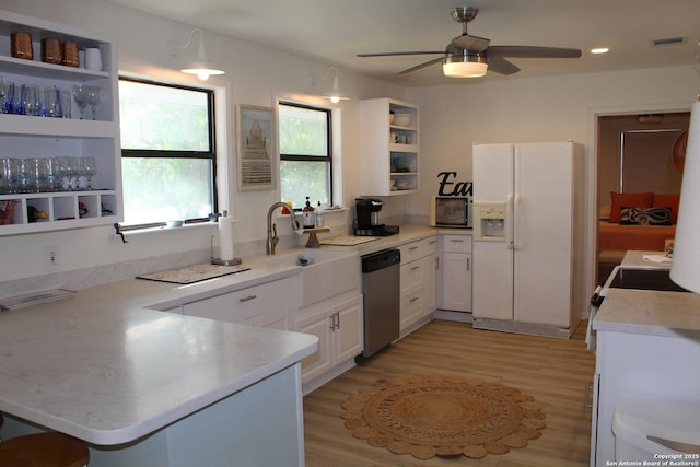 38 Peggy, Palacios, TX 77465 - kitchen with white refrigerator with ice dispenser, stainless steel dishwasher, open shelves, black microwave, and a peninsula