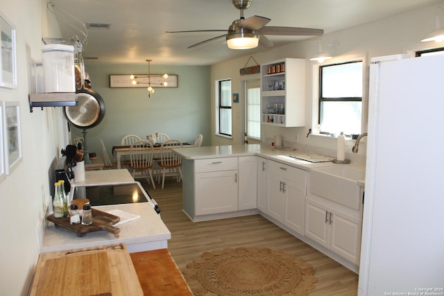 38 Peggy, Palacios, TX 77465 - kitchen with freestanding refrigerator, a sink, a peninsula, light wood-style flooring, and a ceiling fan
