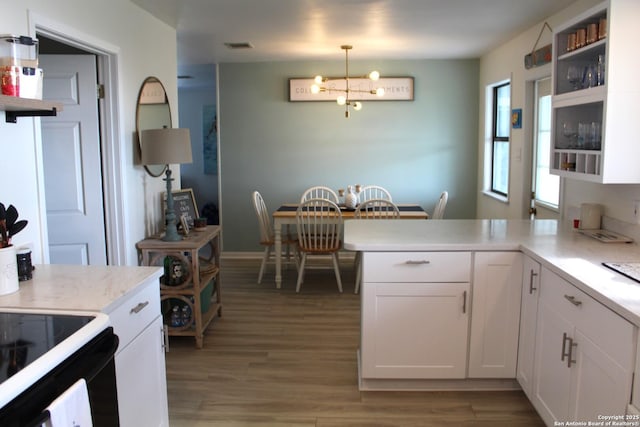 38 Peggy, Palacios, TX 77465 - kitchen with a chandelier, light countertops, light wood-type flooring, and white cabinets