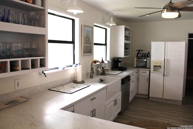 38 Peggy, Palacios, TX 77465 - kitchen with white fridge with ice dispenser, stainless steel dishwasher, a sink, black microwave, and white cabinets