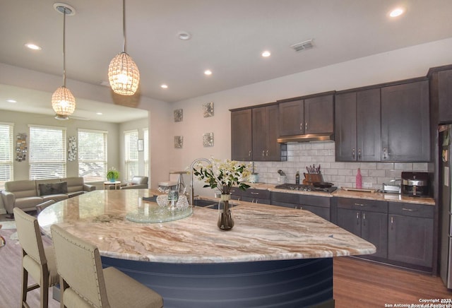 14139 Sam Houston, San Antonio, TX 78253 - kitchen with wood finished floors, stainless steel gas cooktop, decorative backsplash, light stone counters, and recessed lighting