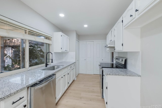 6518 Spring Hurst Dr, San Antonio, TX 78249 - kitchen with appliances with stainless steel finishes, a sink, under cabinet range hood, light wood-style flooring, and white cabinetry
