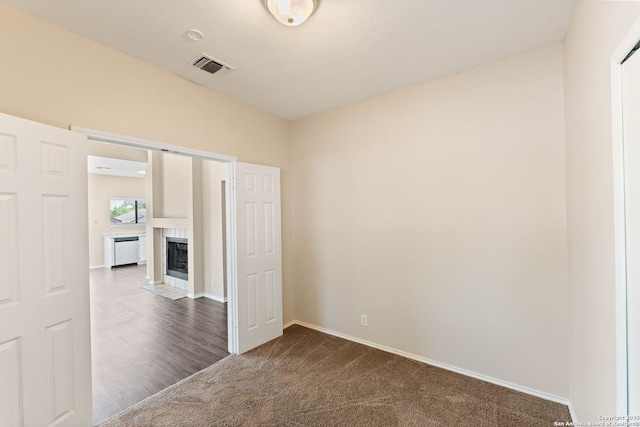 5626 Spring Sunshine, San Antonio, TX 78247 - empty room featuring dark colored carpet, baseboards, and a tiled fireplace