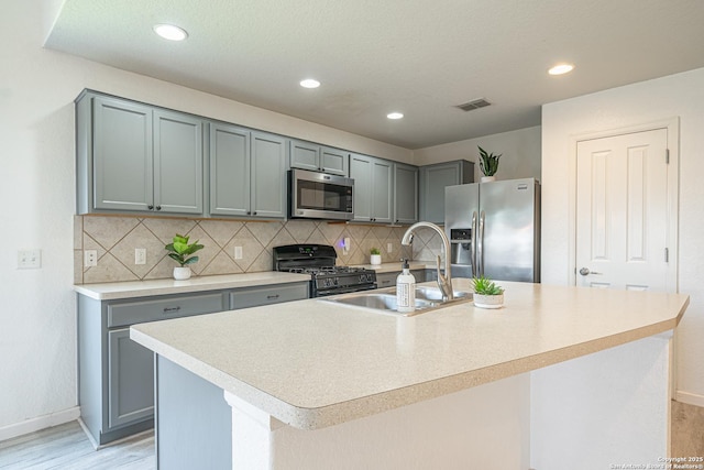 3407 Maguey Trl, San Antonio, TX 78245 - kitchen with stainless steel appliances, a sink, baseboards, gray cabinetry, and recessed lighting