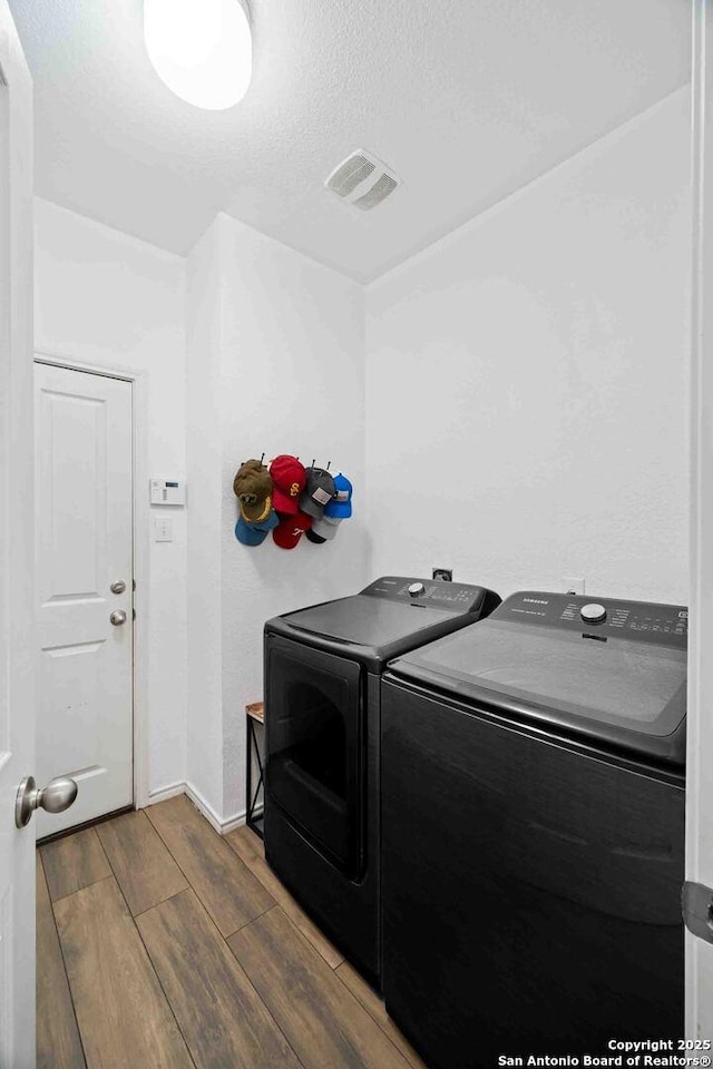 3714 Cotoneaster, San Antonio, TX 78261 - laundry room featuring washing machine and clothes dryer, wood finished floors, a textured ceiling, and baseboards