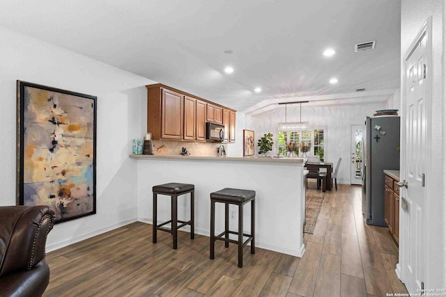 3714 Cotoneaster, San Antonio, TX 78261 - kitchen featuring black microwave, a peninsula, freestanding refrigerator, wood finished floors, and recessed lighting