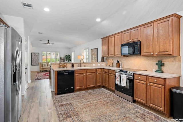 3714 Cotoneaster, San Antonio, TX 78261 - kitchen with black appliances, a sink, a peninsula, brown cabinets, and recessed lighting