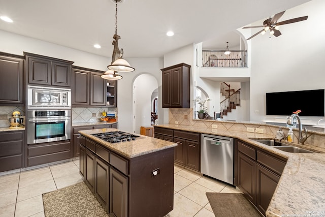 846 Fawnway, San Antonio, TX 78260 - kitchen featuring stainless steel appliances, a sink, arched walkways, dark brown cabinetry, and backsplash