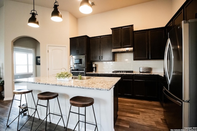 12805 Big Tank Rnch, San Antonio, TX 78245 - kitchen featuring stainless steel appliances, arched walkways, dark wood-style floors, backsplash, and a high ceiling