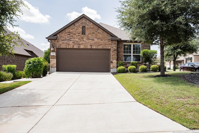 12805 Big Tank Rnch, San Antonio, TX 78245 - view of front of house featuring brick siding, a garage, a front yard, concrete driveway, and stone siding
