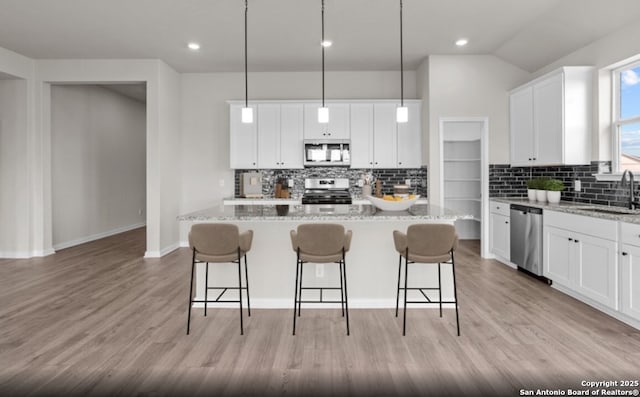 6415 Morgan Gln, San Antonio, TX 78253 - kitchen featuring stainless steel appliances, decorative backsplash, a sink, white cabinets, and lofted ceiling