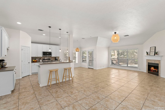 1015 Water Lily, San Antonio, TX 78260 - kitchen featuring appliances with stainless steel finishes, open floor plan, light tile patterned floors, backsplash, and vaulted ceiling