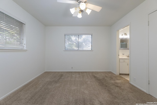 4326 Hall Park, San Antonio, TX 78218 - unfurnished bedroom with light colored carpet, baseboards, connected bathroom, a sink, and ceiling fan