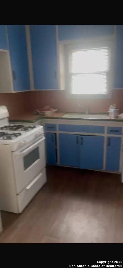 466 Bryn Mawr, San Antonio, TX 78209 - kitchen with white gas range and blue cabinetry