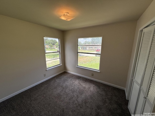 827 Horseshoe, Universal City, TX 78148 - unfurnished bedroom with dark carpet, baseboards, and a closet