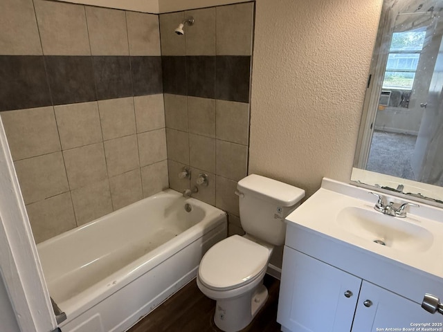 827 Horseshoe, Universal City, TX 78148 - bathroom featuring a textured wall, toilet, vanity, shower / washtub combination, and wood finished floors