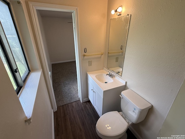 827 Horseshoe, Universal City, TX 78148 - half bath with vanity, wood finished floors, toilet, a textured wall, and baseboards