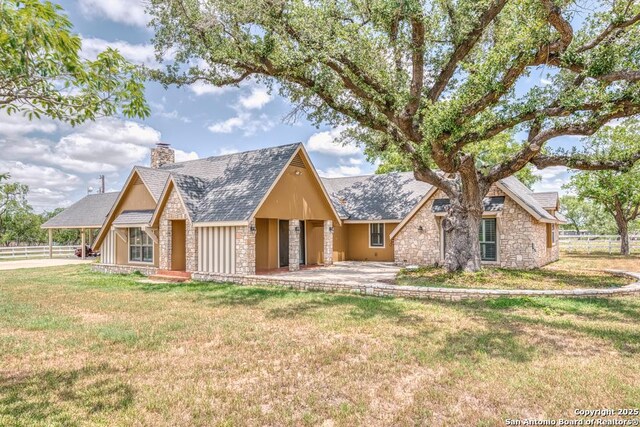701 Steele, Smiley, TX 78159 - view of front of house with stone siding, a chimney, and roof with shingles