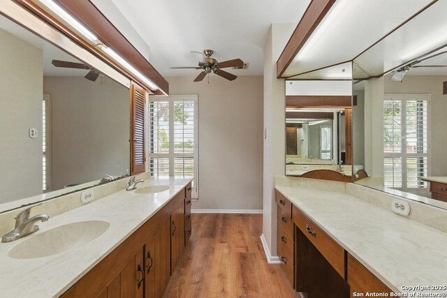 701 Steele, Smiley, TX 78159 - bathroom featuring ceiling fan, wood finished floors, baseboards, and double vanity