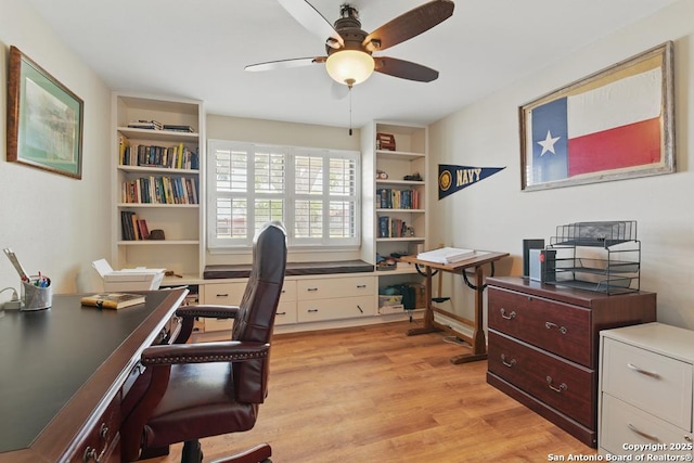 701 Steele, Smiley, TX 78159 - home office featuring a ceiling fan, light wood-type flooring, and built in shelves