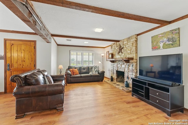 701 Steele, Smiley, TX 78159 - living room featuring beam ceiling, light wood-style floors, a stone fireplace, and crown molding