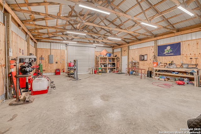 701 Steele, Smiley, TX 78159 - garage featuring a workshop area, metal wall, and electric panel