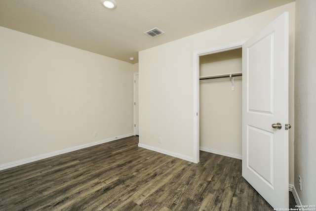 2434 Bermuda, San Antonio, TX 78222 - unfurnished bedroom with dark wood-type flooring, a closet, and baseboards