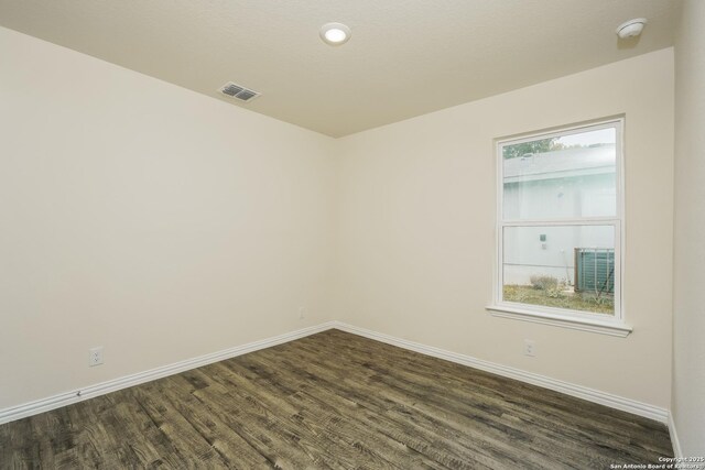 2434 Bermuda, San Antonio, TX 78222 - spare room with baseboards, dark wood finished floors, and a smoke detector