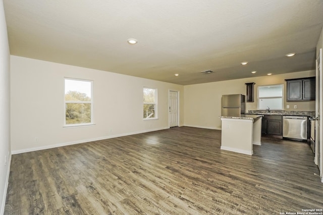 2434 Bermuda, San Antonio, TX 78222 - unfurnished living room with a sink, healthy amount of natural light, dark wood finished floors, baseboards, and recessed lighting