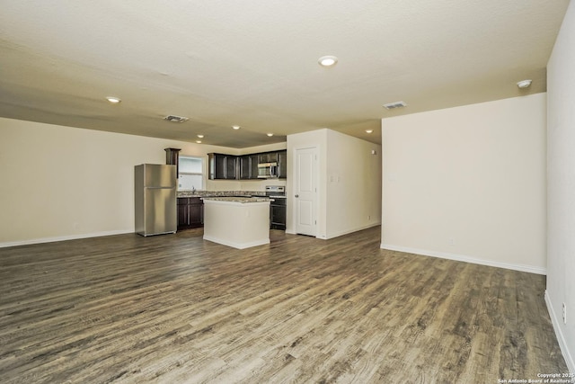 2434 Bermuda, San Antonio, TX 78222 - unfurnished living room featuring dark wood-style floors, baseboards, recessed lighting, and a sink
