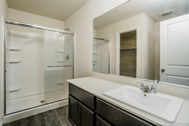 2434 Bermuda, San Antonio, TX 78222 - full bathroom with a shower stall, wood finished floors, vanity, and a walk in closet