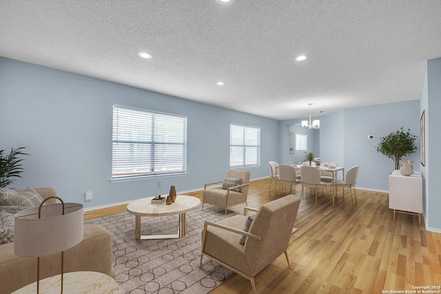 11202 Candle Park, San Antonio, TX 78249 - living room with a textured ceiling, a chandelier, light wood finished floors, recessed lighting, and baseboards