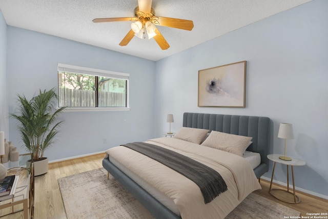 11202 Candle Park, San Antonio, TX 78249 - bedroom featuring wood finished floors, baseboards, a textured ceiling, and ceiling fan